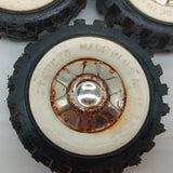 Three original Structo truck tires with white walls and hubs.